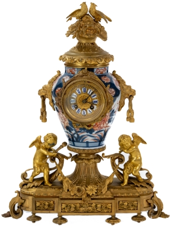 Stamp of Feldman International Auctions » Mobilier, Objets d'Art & Design / Furniture, Objets d'Art & Design Garniture de cheminée dans le style du XVIIIème siècle comprenant une pendule et deux candélabres, associés à des vases Imari. XIXème siècle