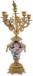 Stamp of Feldman International Auctions » Mobilier, Objets d'Art & Design / Furniture, Objets d'Art & Design Garniture de cheminée dans le style du XVIIIème siècle comprenant une pendule et deux candélabres, associés à des vases Imari. XIXème siècle